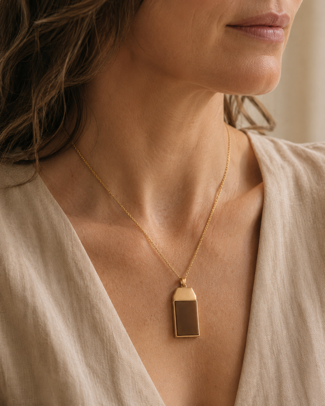Close-up of a pendant resting on cloth — an object that carries both safety and stigma